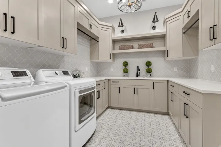 U-shaped countertop space with a black gooseneck faucet, light gray cabinetry, and patterned tile flooring
