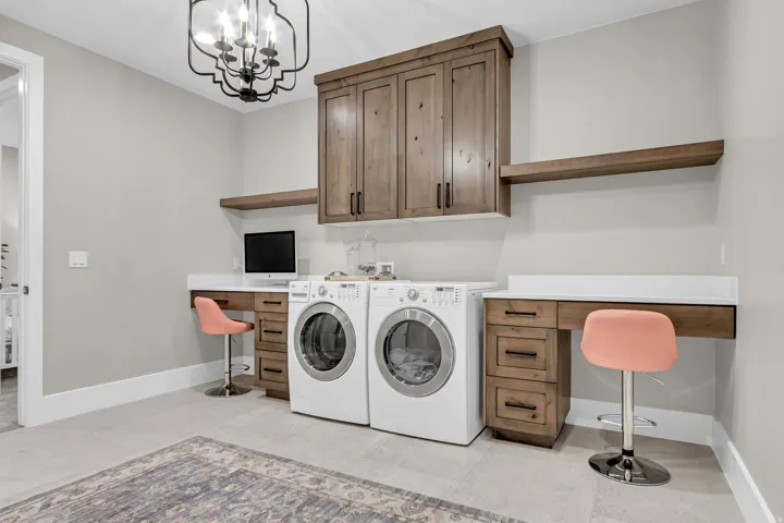 Laundry area with built-in cabinetry, floating shelves, and integrated desk space