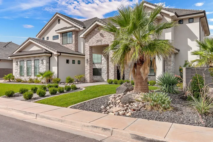 Contemporary exterior with stone veneer accents, stucco siding, and a multi-pitch roof