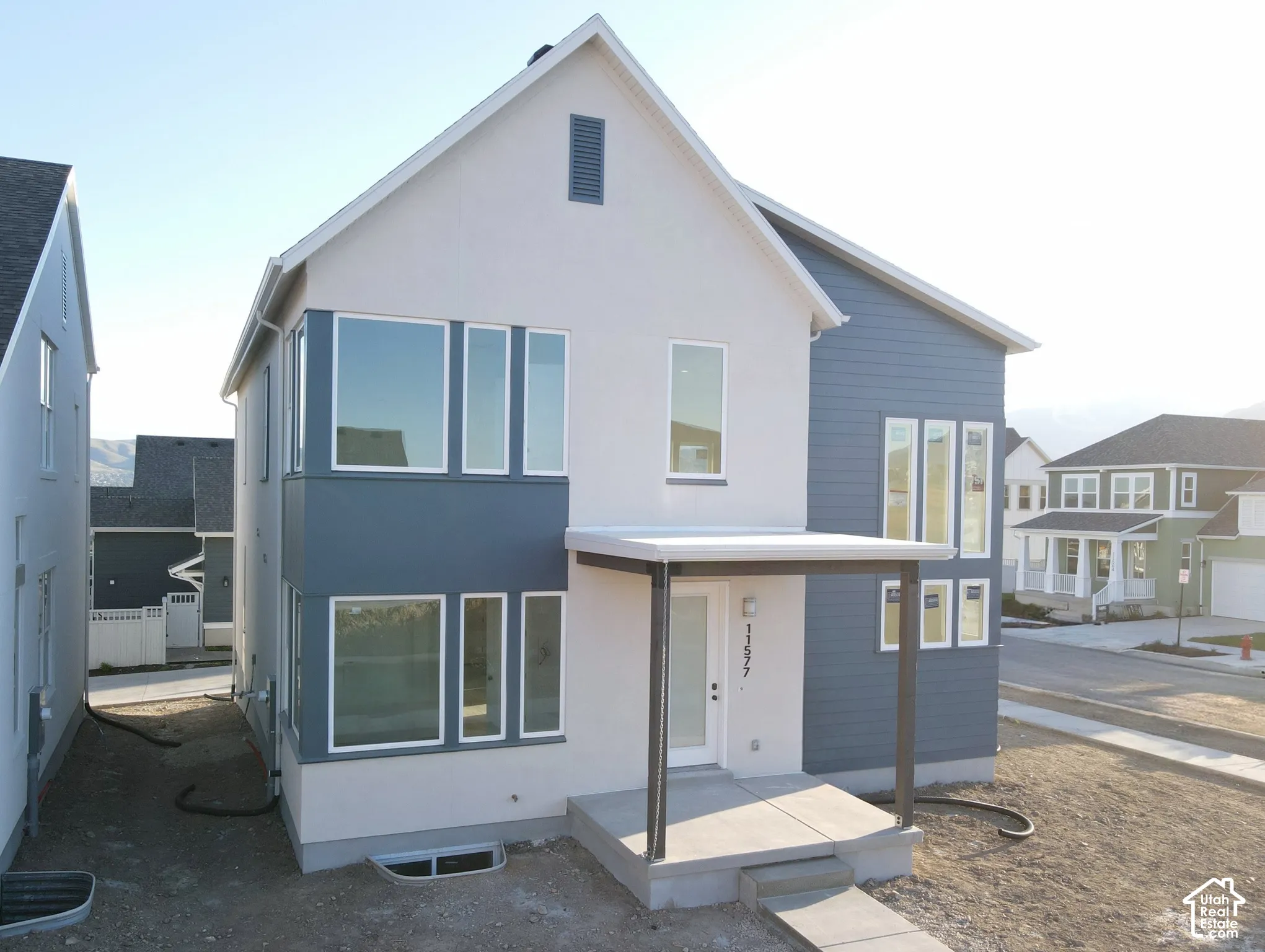 Contemporary exterior design featuring a covered entryway, multiple windows, and a combination of siding and stucco finishes