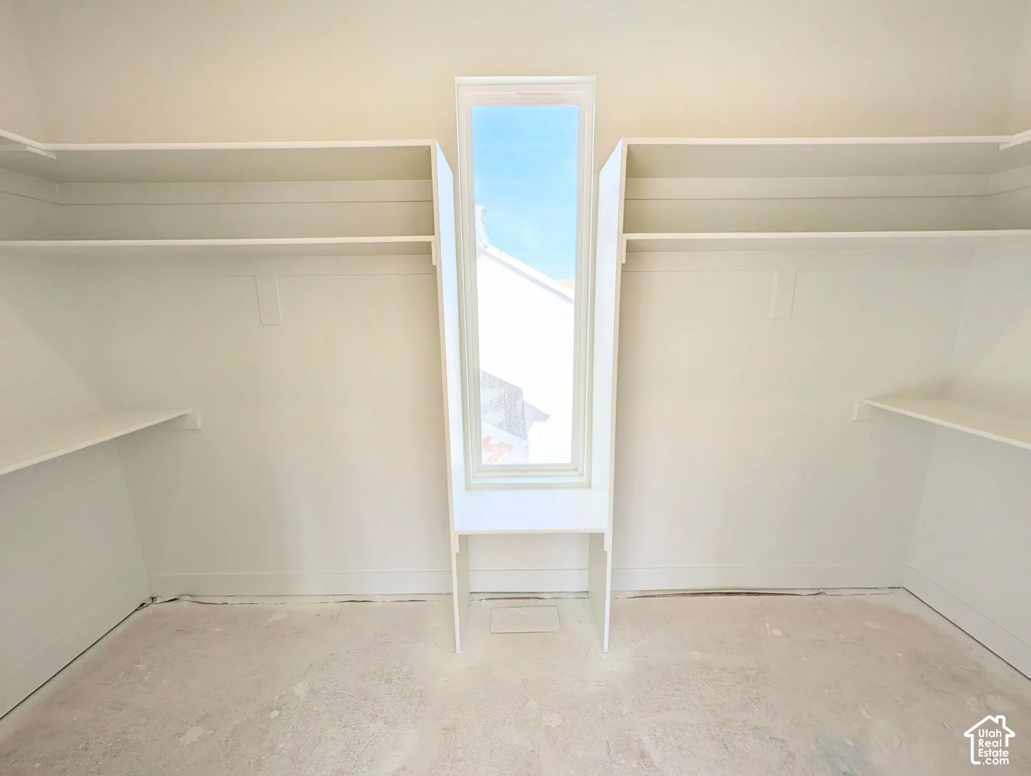 Integrated shelving and hanging rods, center window, and light-toned walls