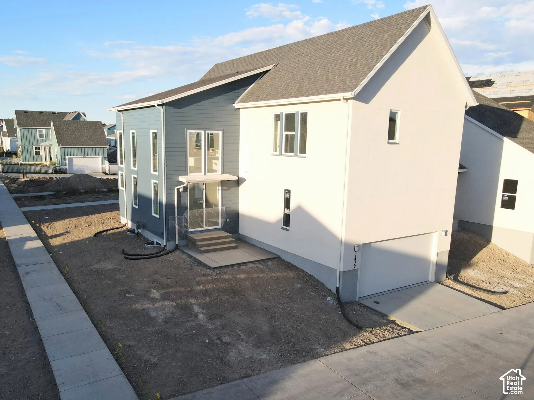 Modern exterior design featuring multiple siding textures, a prominent attached garage, and multiple large windows