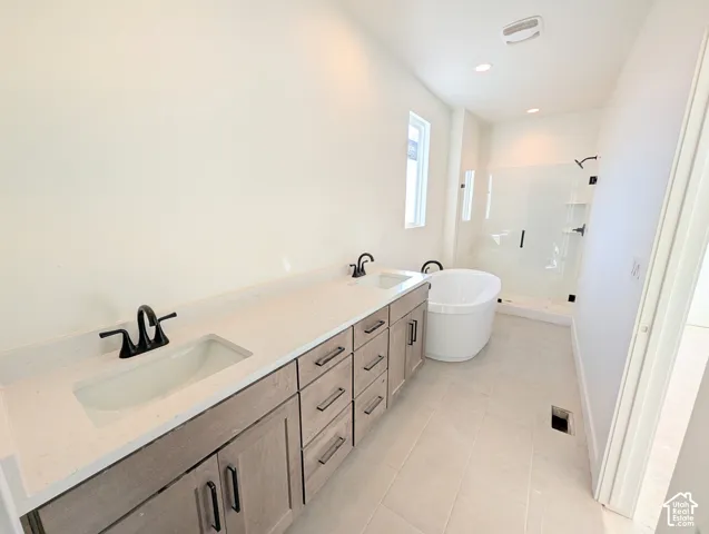 Dual sink vanity with light wood-finish cabinetry, white countertop, matte black fixtures, free-standing tub, and glass-enclosed shower