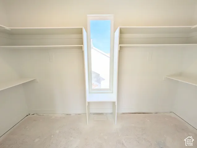 Integrated shelving and hanging rods, center window, and light-toned walls