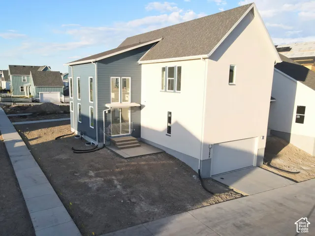 Modern exterior design featuring multiple siding textures, a prominent attached garage, and multiple large windows