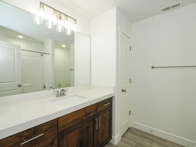 Spacious vanity with a white countertop and wood-finish cabinetry