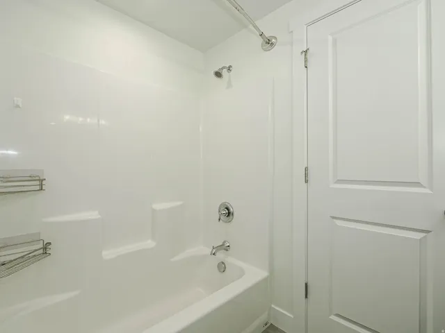 White tub and shower combination with chrome fixtures
