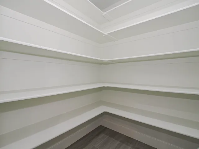 Built-in shelving with multiple levels, white finishes, and wood-finish flooring