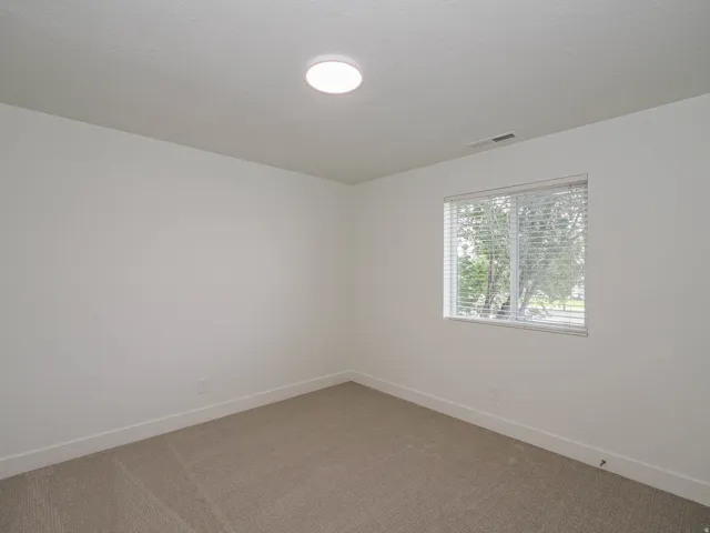 Recessed ceiling light, neutral wall paint, horizontal window blinds, and carpeted flooring