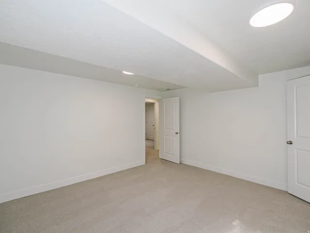 Neutral-toned carpeting, white walls, and recessed lighting