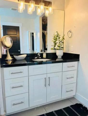 White vanity with a black countertop and an integrated white basin