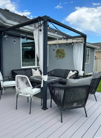 Exterior deck featuring light gray composite decking and a black metal pergola