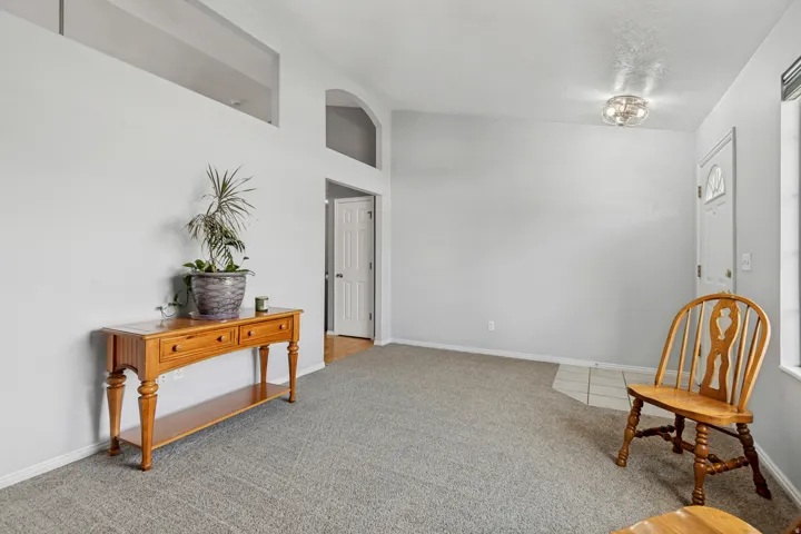 Recessed archway, transom window, flush mount lighting, paneled interior door, and light gray wall finish