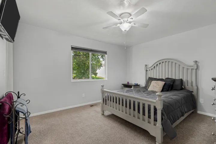 Carpeted flooring, window with blinds, ceiling fan with integrated lighting, and neutral wall tones