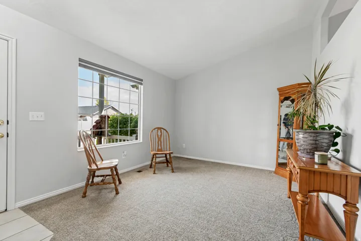 Vaulted ceiling, grid-pattern window, light gray wall color, light-toned carpet, and white trim