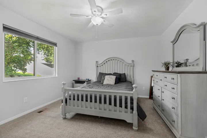 Wall-to-wall carpeting and a ceiling fan with integrated lighting