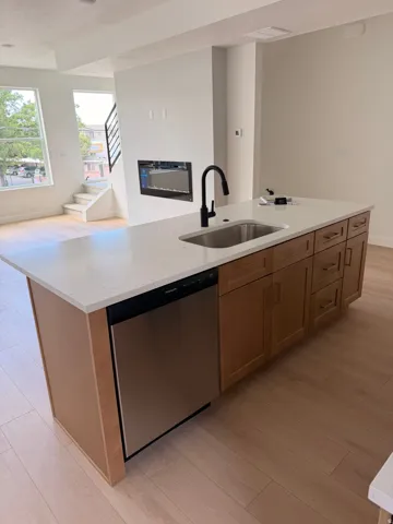 Kitchen island with an undermount sink, matte black faucet, and stainless steel dishwasher
