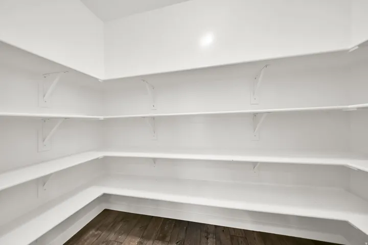 Wrap-around white shelving, extensive storage, wood-finish flooring