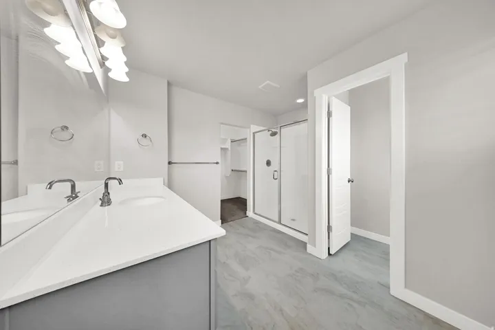 Double vanity with white countertop, chrome fixtures, and undermount sinks