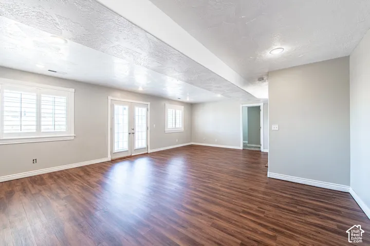 Spacious room featuring wood-finish flooring, light gray walls, and recessed lighting