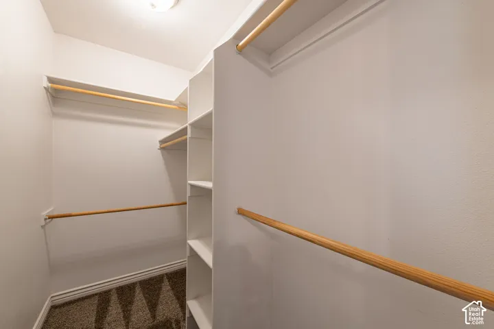 Walk-in closet featuring built-in shelving, multiple hanging rods, and recessed lighting