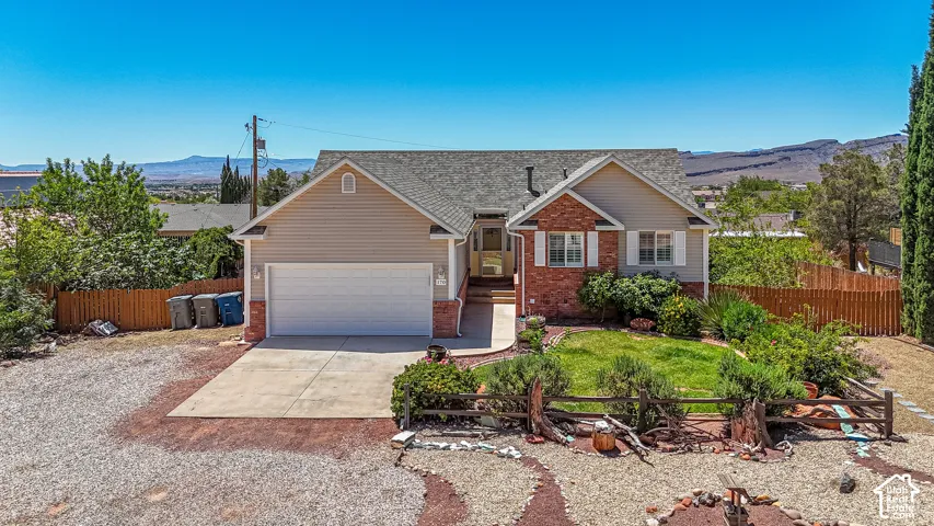 Siding and brick exterior with attached garage, concrete driveway, and front lawn