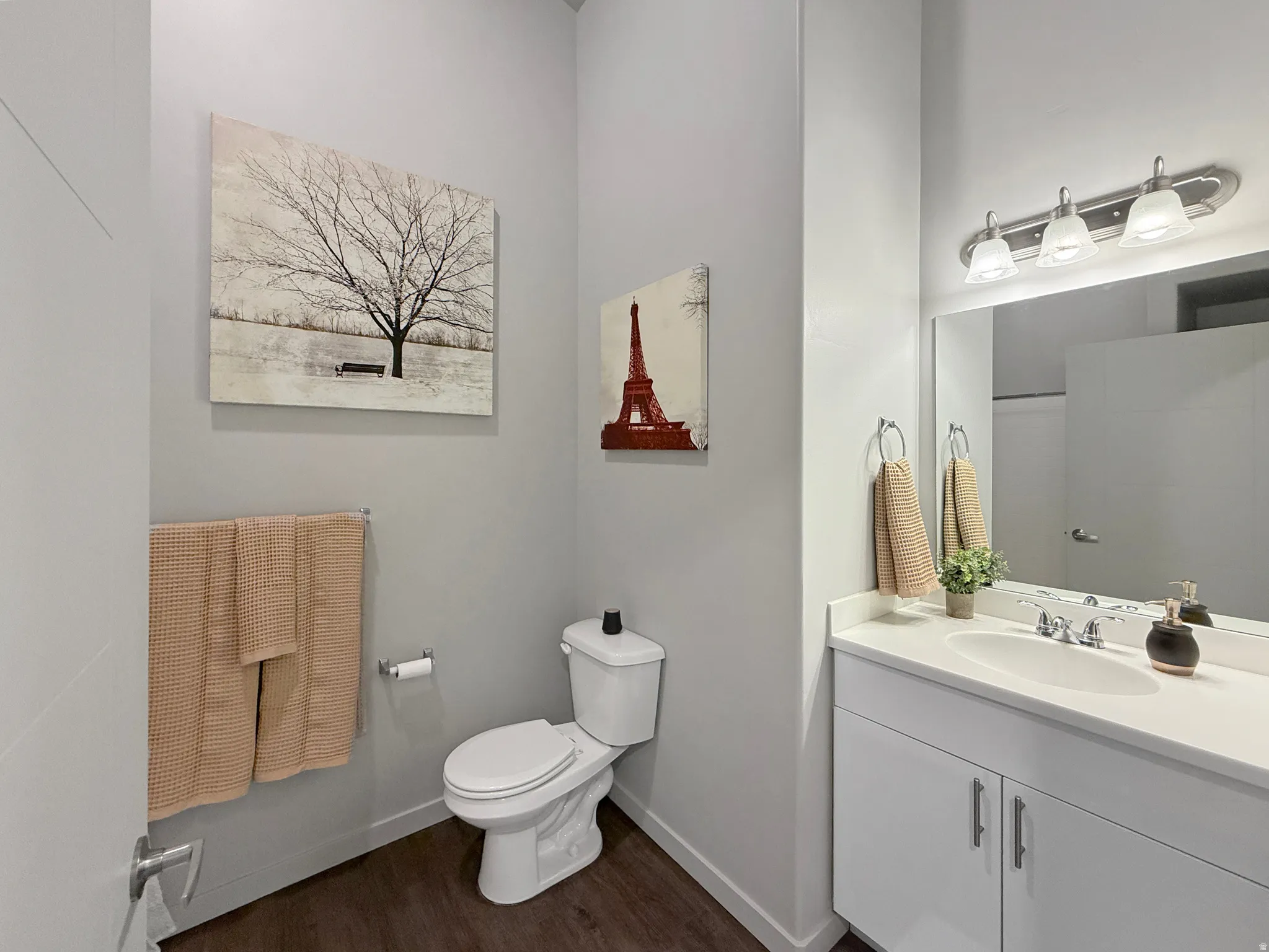 White vanity with double-door cabinetry, polished chrome fixtures, and a rectangular undermount sink