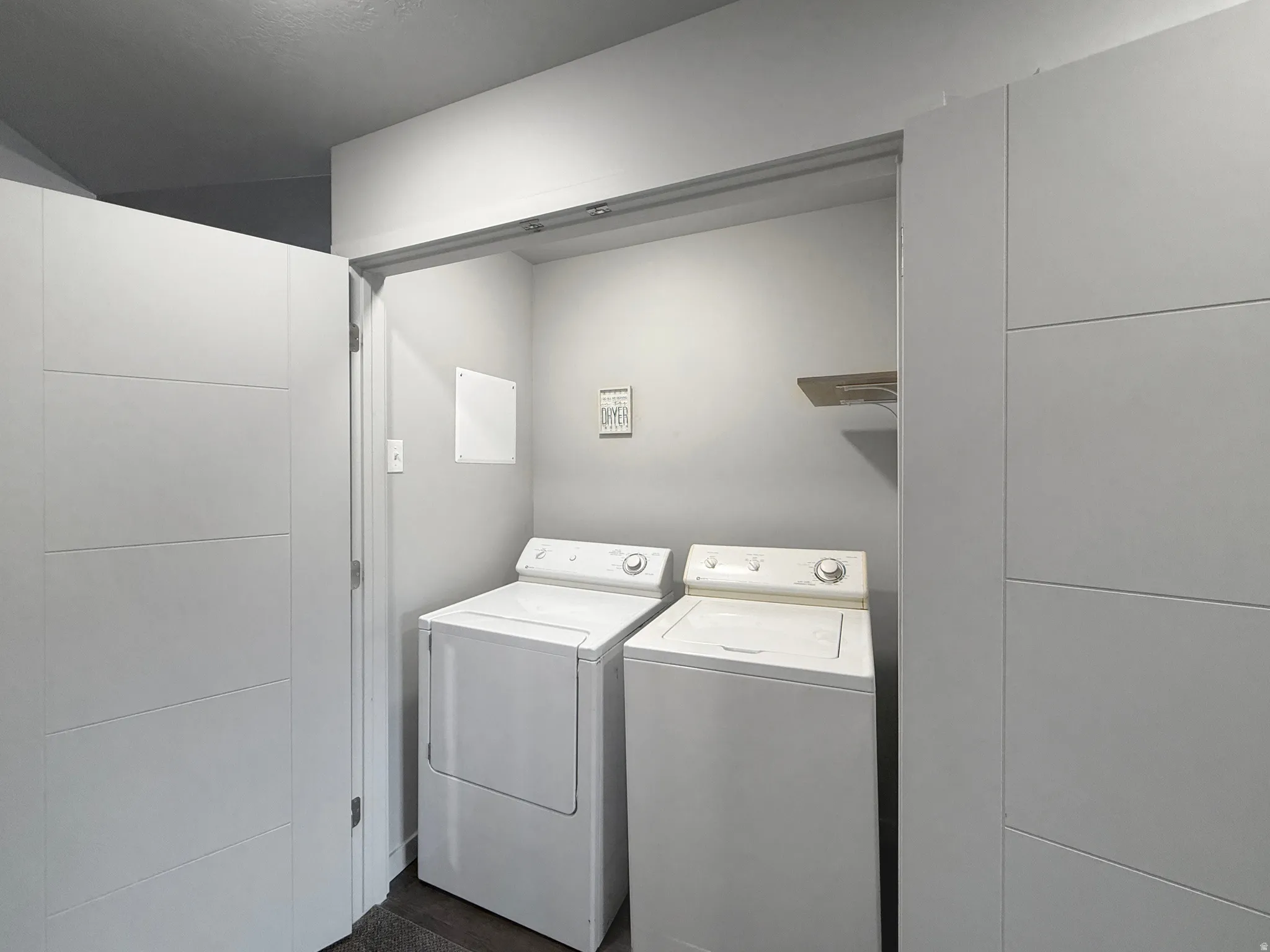 Dedicated laundry area with a built-in wood-finish shelf