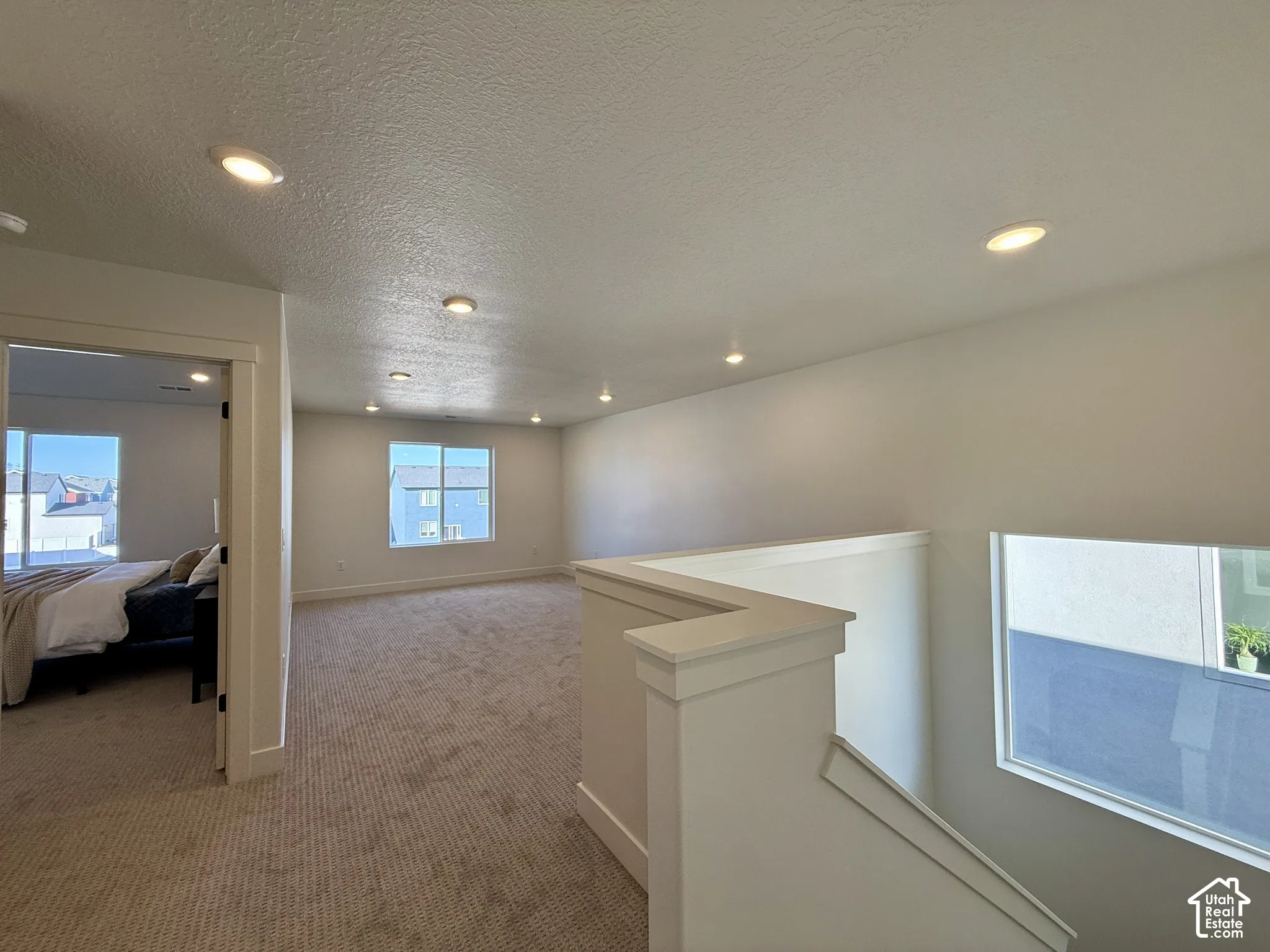 Open floor plan featuring recessed lighting, wall-to-wall carpeting, and neutral paint finishes
