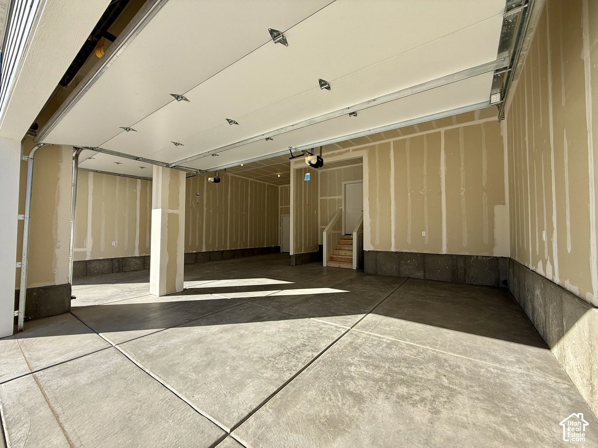 Spacious multi-car garage featuring a concrete floor, overhead door system, and structural support pillar