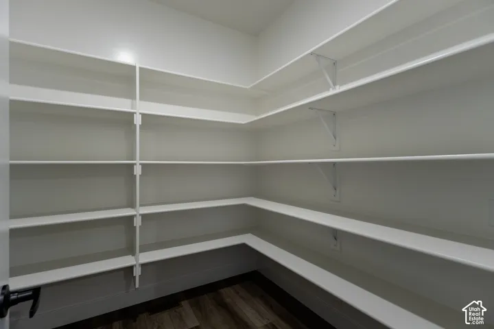 Extensive built-in shelving with white finishes and wood-finish flooring