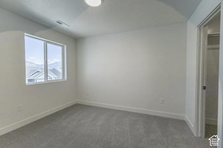 Neutral white wall paint, gray carpet flooring, white trim, recessed lighting, and a white framed window