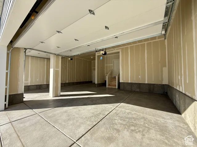 Spacious multi-car garage featuring a concrete floor, overhead door system, and structural support pillar