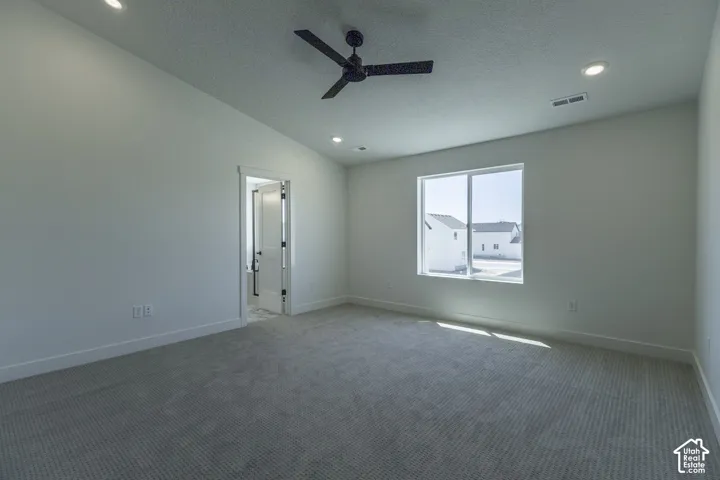 Recessed ceiling lighting, ceiling fan, large window, light-toned carpeting, and a white interior door