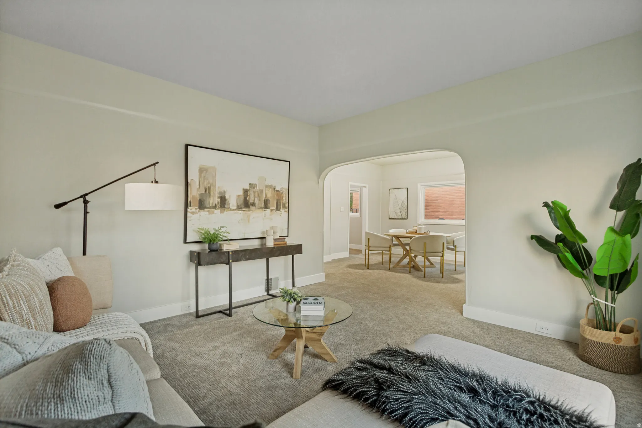 Archway opening into an additional room, light-toned wall paint, and gray carpeting