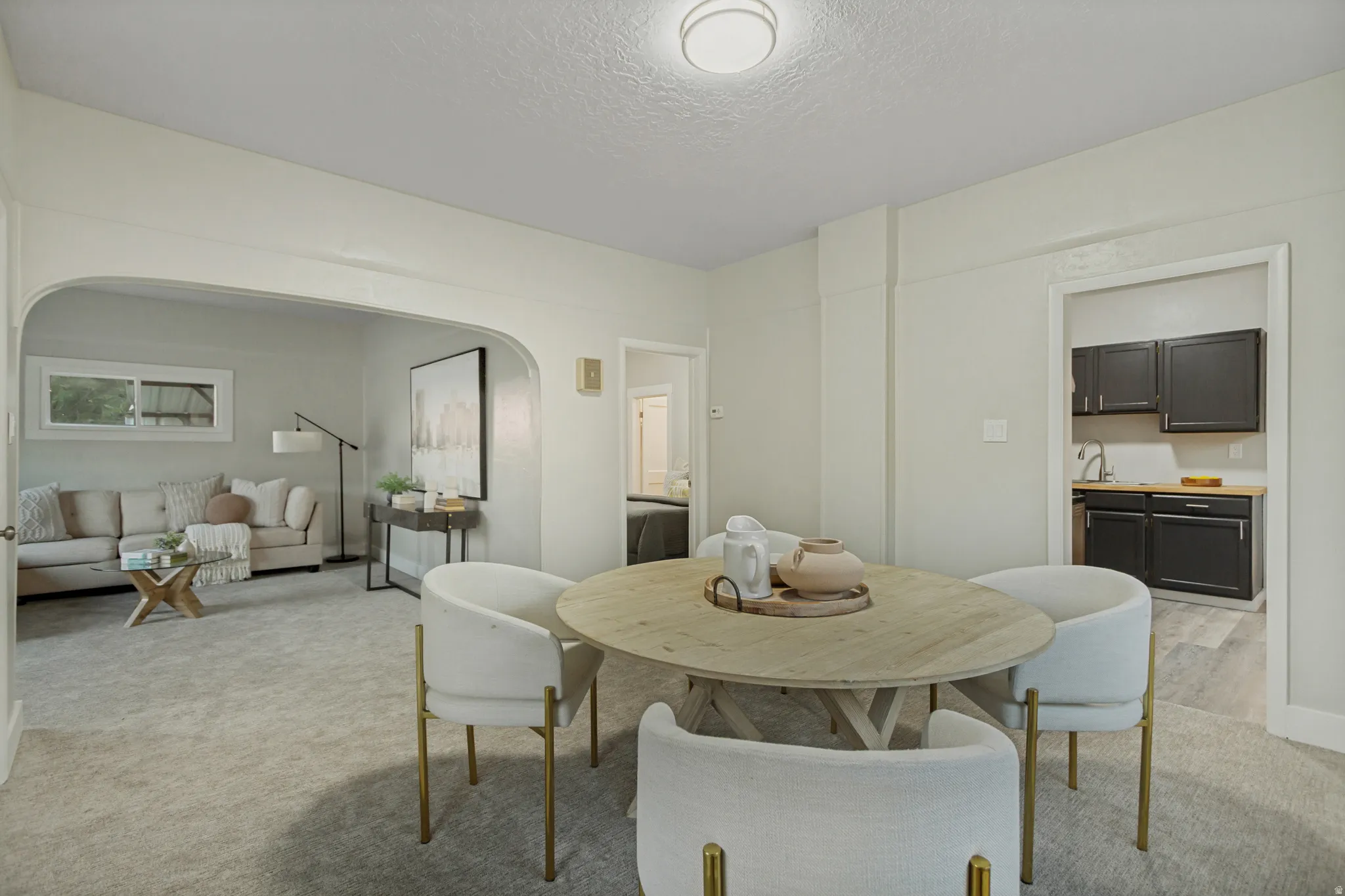 Open-concept living space with light gray carpet and recessed lighting