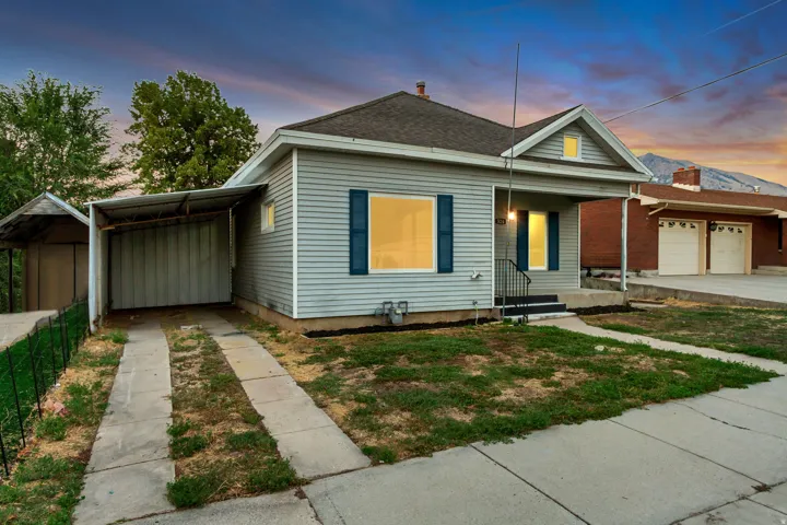 Siding exterior with a covered front porch, an attached carport, and a separate covered structure