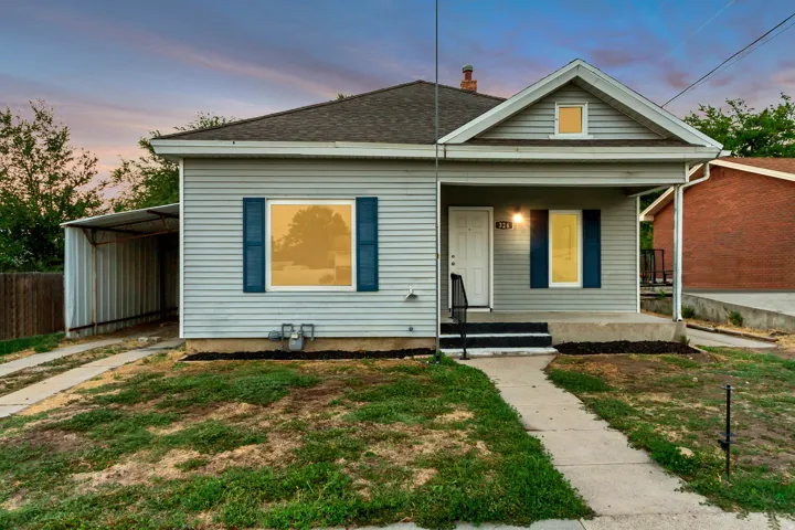 Gable roofline, covered front porch, light gray siding, dark blue shutters, covered side carport