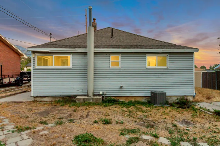 Light blue horizontal siding, brown shingle roof, and multiple windows