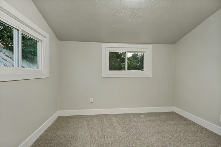 Light gray walls, white trim, and gray carpet