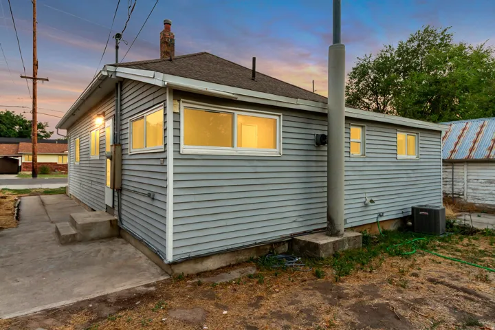 Siding exterior with multiple windows, concrete patio, and an outdoor HVAC unit