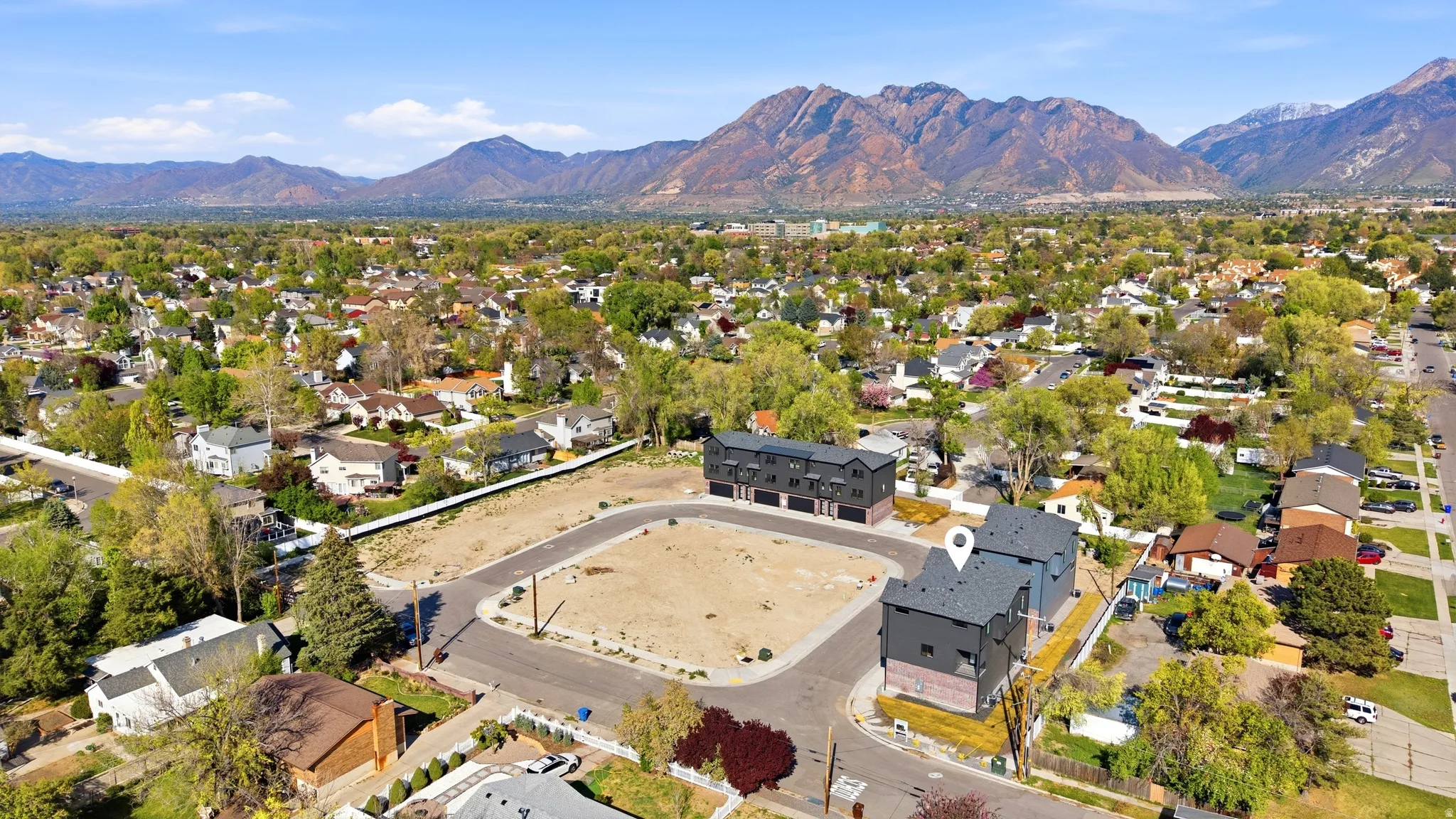 Aerial perspective showcasing mountainous terrain, surrounding suburban development, and a paved cul-de-sac