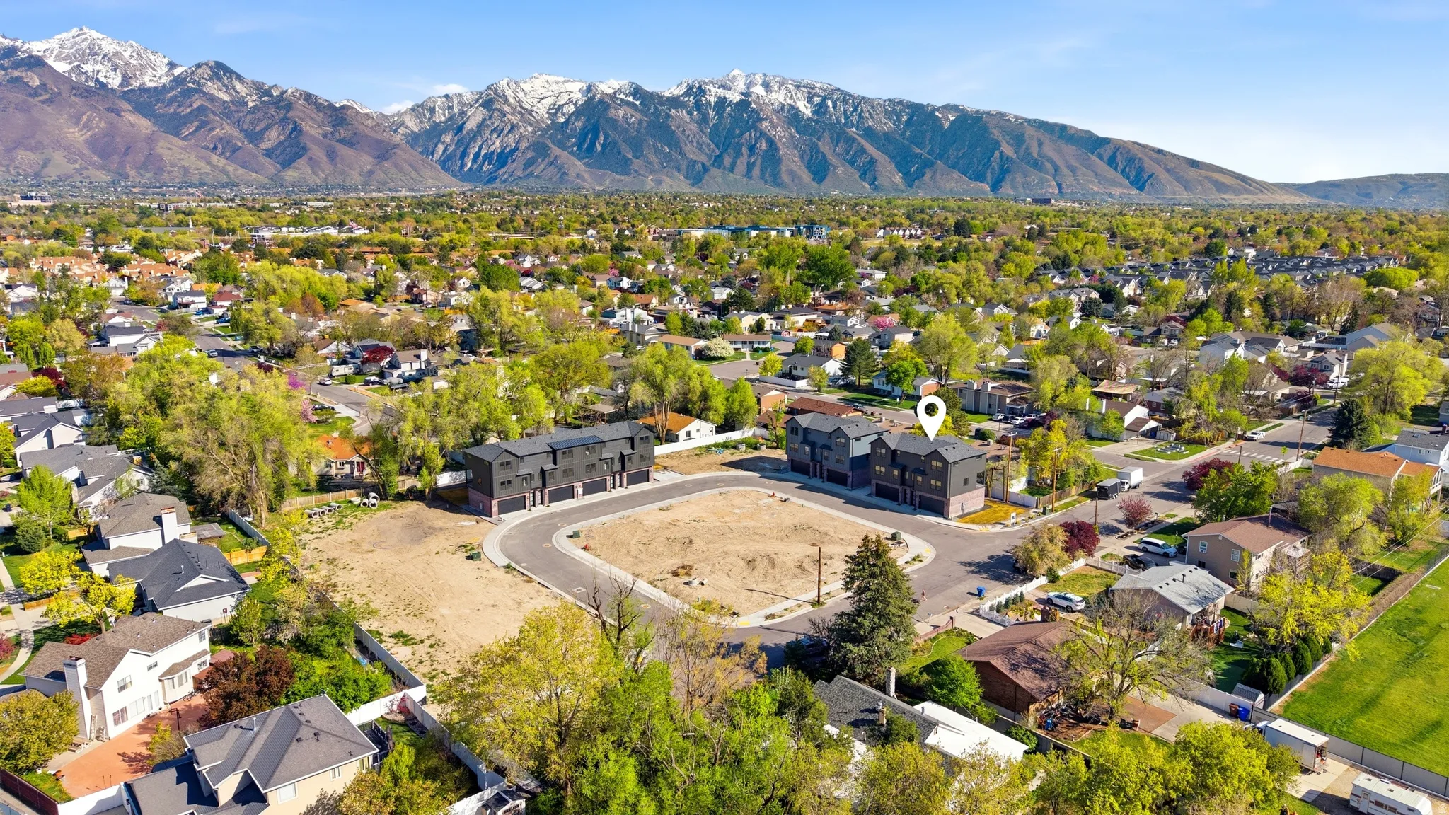Modern multi-unit development with attached garages and paved driveways