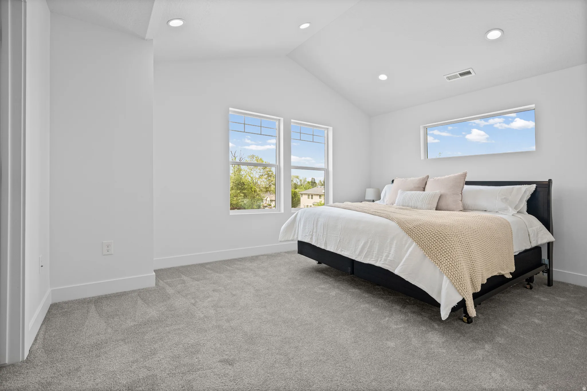 Vaulted ceilings, recessed lighting, and large windows with transom details