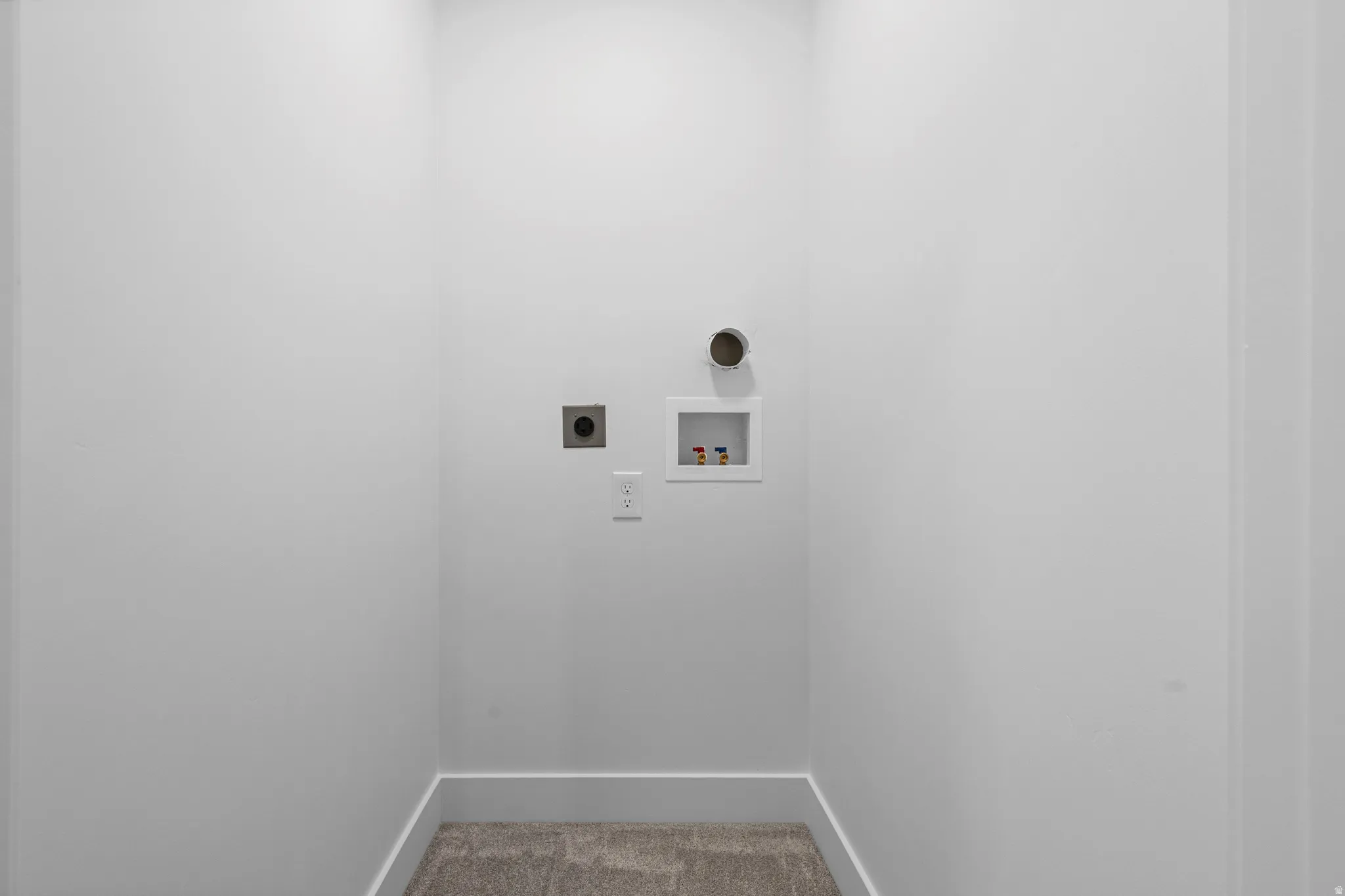Carpeted flooring, white walls, and dedicated appliance hookups