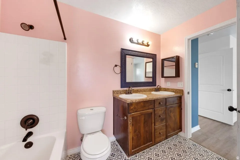 Double vanity with integrated sinks, granite-style countertop, and wood-finish cabinetry