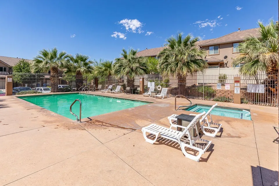Outdoor swimming pool with integrated spa and surrounding concrete decking