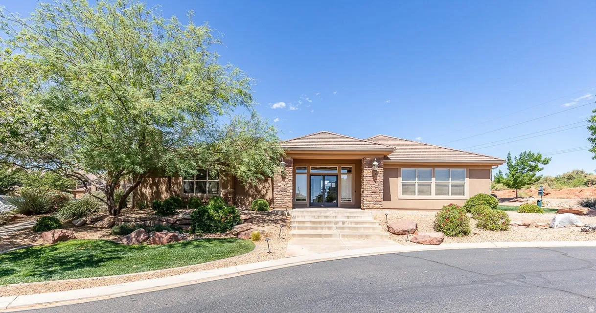 Stucco exterior with brick stone accents, multi-pane windows, and a tiered concrete entry