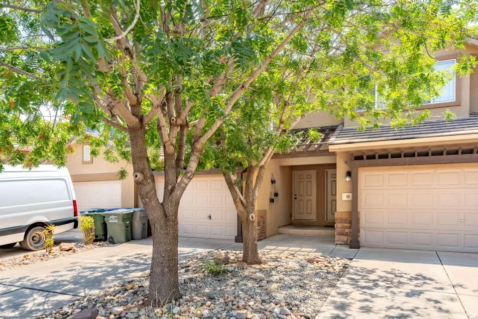 Stucco exterior with stone accents, dual garage doors, and a covered entry