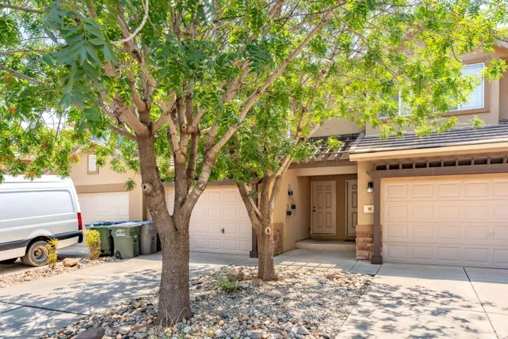 Stucco exterior with stone accents, dual garage doors, and a covered entry